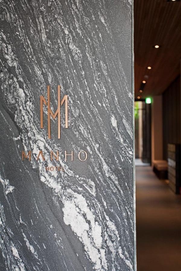 縵和旅居入口石材上的 MANHO 標誌